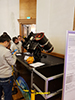 Attendees around a table looking at an SLR instrument