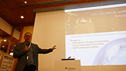 Male speaker in front of large screen